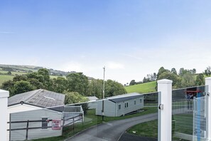 Un quartier résidentiel composé de maisons mobiles, doté d’une allée d’accès fermée par un portail et offrant une vue dégagée sur le paysage environnant.