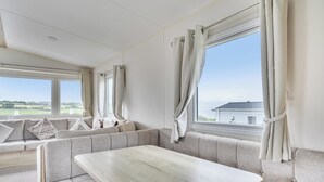 A modern interior with a seating area, large windows, and a view of the outdoors.