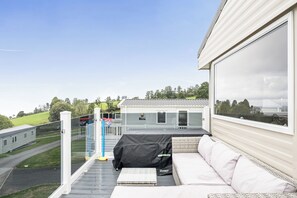 A balcony with a sofa, a covered grill, and a basketball hoop. - Ty dee seaview escapes (Looe)