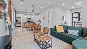Un salon moderne avec un canapé, une table basse et un téléviseur.