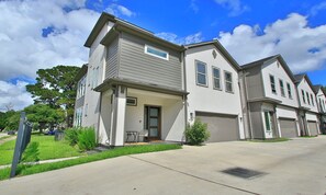 A modern two-story residential building with a garage, a covered porch, and a well-maintained lawn. - 15 Mins NRG, Modern Home w/ 3 King Suites & Garage (Houston)