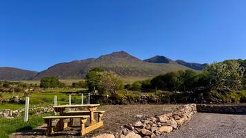 A picnic table in a rural setting with mountains in the background.