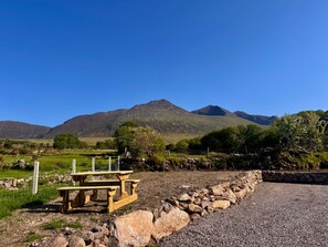 A picnic table in a rural setting with mountains in the background. - Cottage Sleeps 4 with Parking (Killarney)