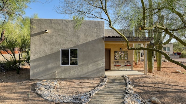 A small, modern house with a stone exterior, a window, and a patio area with a cactus garden. - Saguaro Grove, Built May '26, Smart Lock, Quiet Cul-de-sac (Tucson)