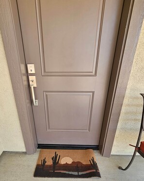 A brown door with a keyhole and a doorbell.