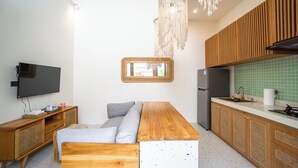 Een moderne keuken met houten kastjes, een inbouwkoelkast en een groot houten kookeiland met zitplaatsen.