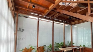 Una habitación con techo de madera, ventanas amplias y una mesa con sillas.