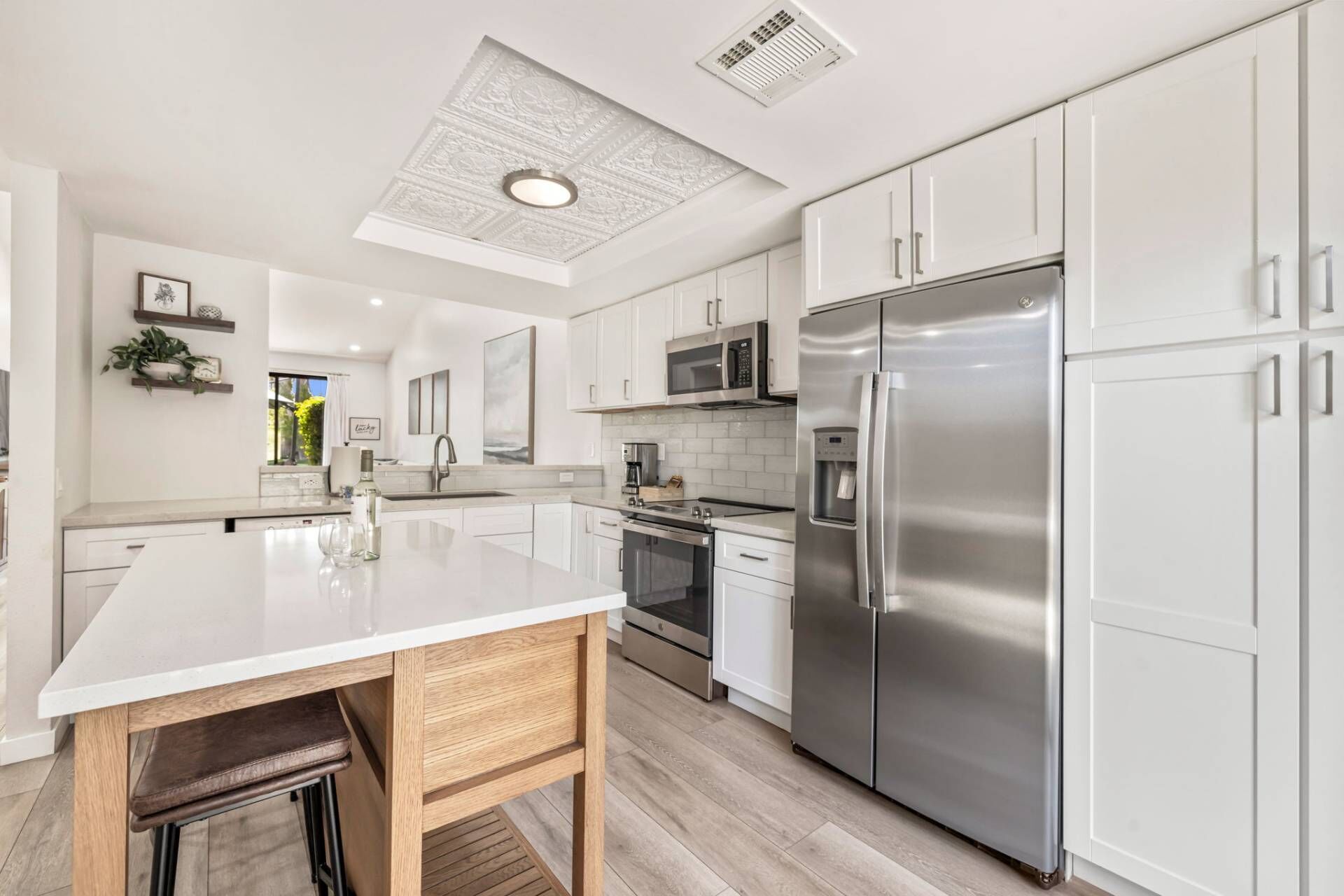 A modern kitchen with white cabinetry, stainless steel appliances, and a central island.