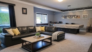 Ein modernes Wohnzimmer mit Ecksofa, Couchtisch und Essbereich mit Kücheninsel.