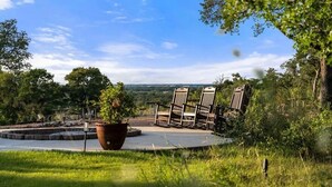 Eine Garten-Terrasse mit Stühlen und einem großen Blumentopf.