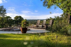 Eine Garten-Terrasse mit Stühlen und einem großen Blumentopf.