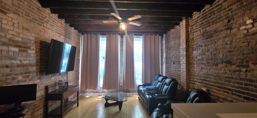 Large 1-bedroom apt with tall ceilings, brick walls, large tv, modern bathroom