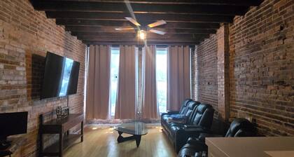 Large 1-bedroom apt with tall ceilings, brick walls, large tv, modern bathroom