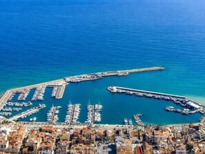 An aerial view of a coastal marina with numerous boats docked, a pier, and a densely built urban area in the foreground. - Suitur Dorado Onintza beachfront apartment with swimming pool (Cambrils)