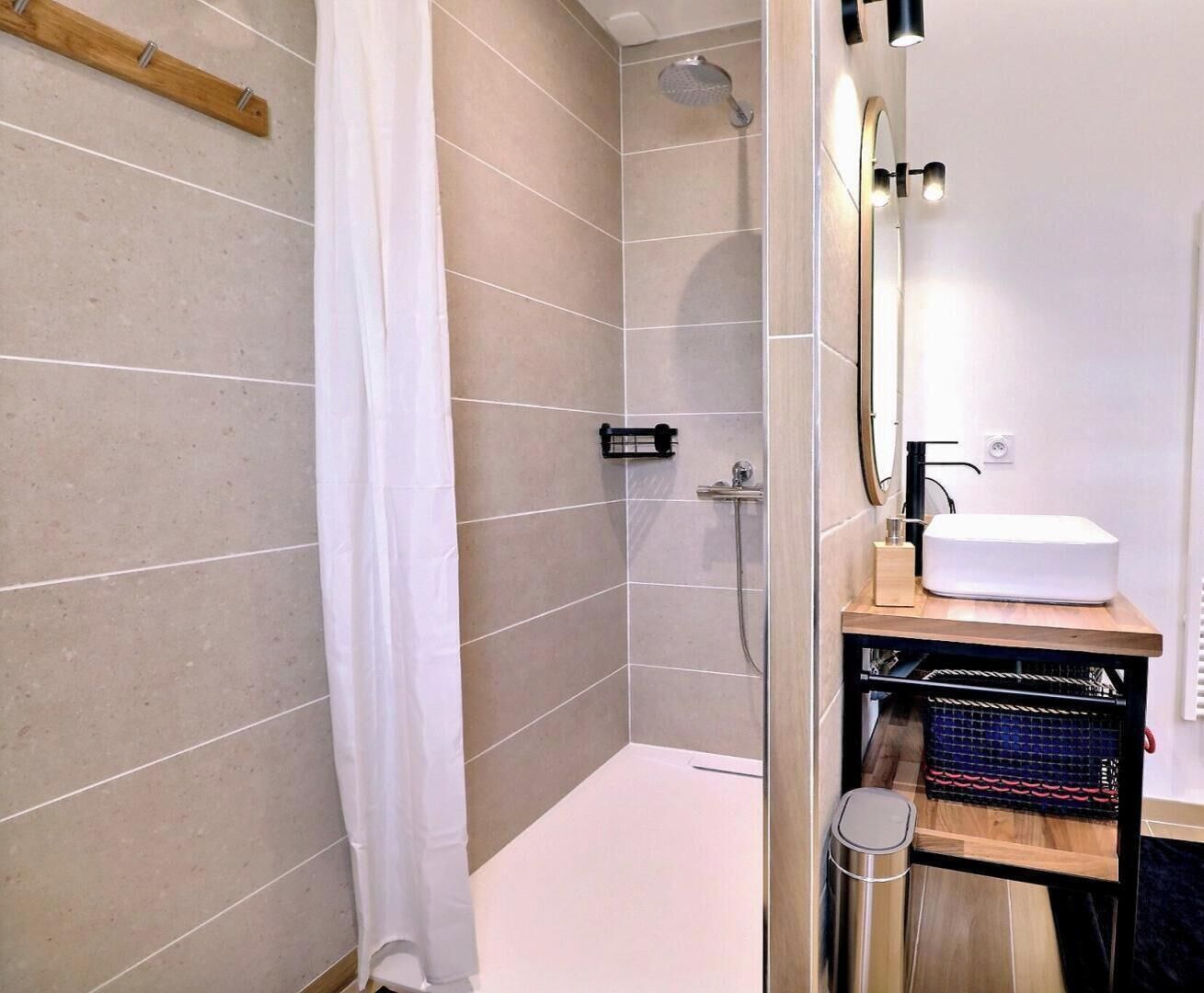 Ein modernes Badezimmer mit Dusche, Waschbecken und Spiegel.