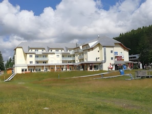 Een hotel met meerdere verdiepingen, balkons, een skilift en een restaurant.