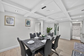 Un comedor moderno con una mesa rectangular dispuesta para cuatro personas, rodeada de sillas.