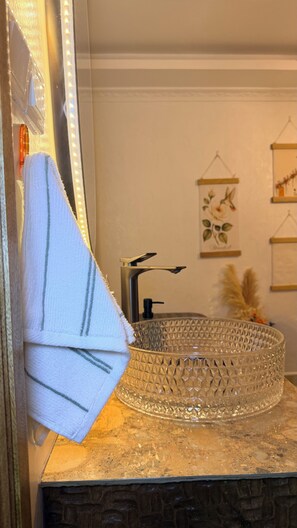 Une salle de bain avec un miroir, un lavabo et des éléments décoratifs sur les murs.