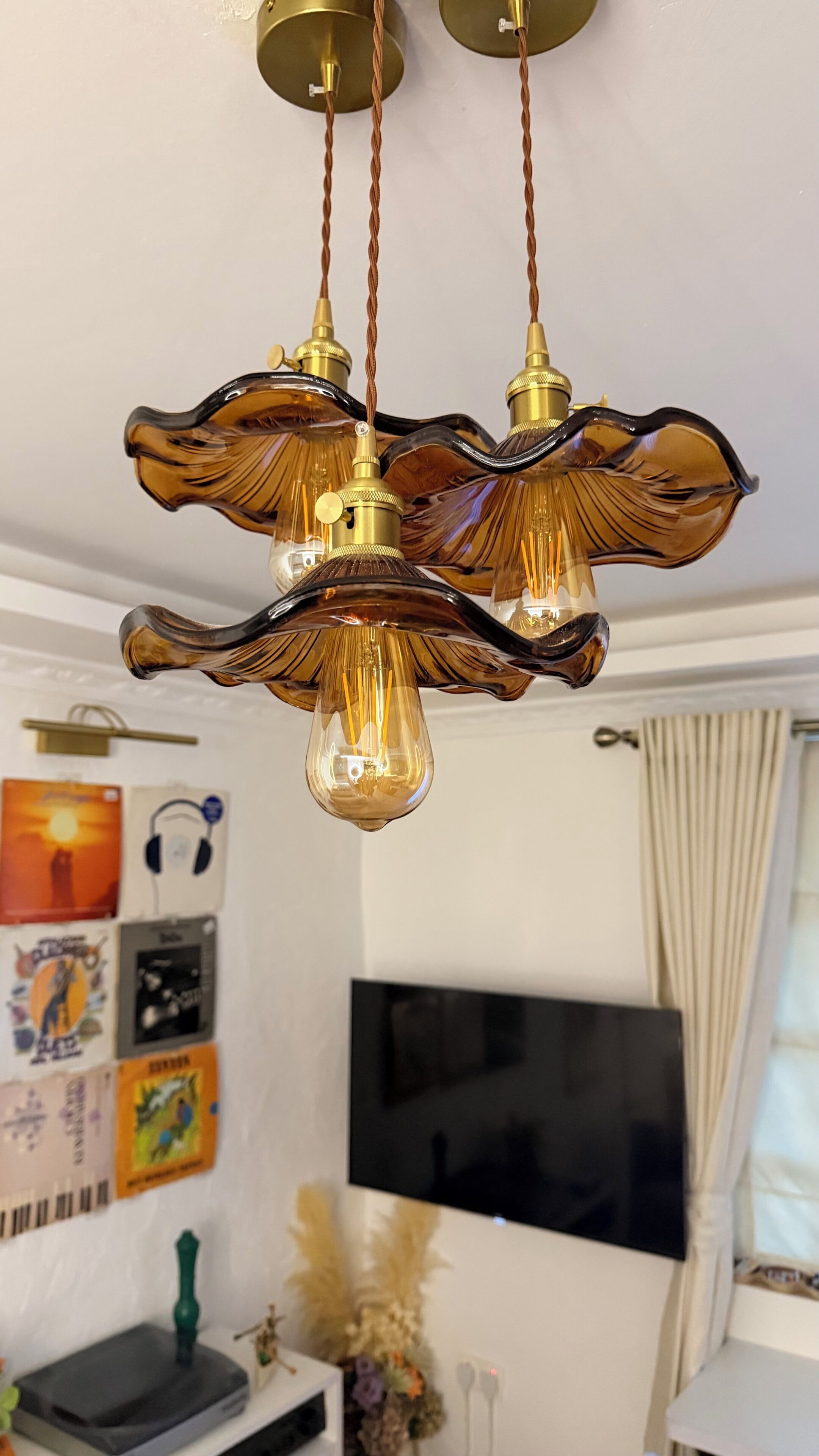 A chandelier with three light bulbs and a decorative element hanging from the ceiling.