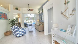 A spacious living area with a ceiling fan, a sofa, a coffee table, and a dining area in the background. - Blue Pelican Stay - New listing with Hot Tub and Heated Pool (Port St. Lucie)