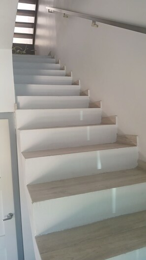 Een trap met houten treden en witte wanden.