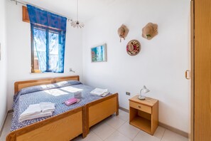 A neatly arranged bedroom with a bed, bedside table, and a small desk with a lamp. - Leuca Relax&Sea n.8d, Castrignano del Capo, Italy (Castrignano del Capo)