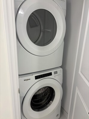 A Whirlpool stacked washer and dryer unit in a corner.