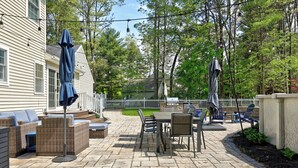 A patio with outdoor furniture, a table, and string lights. - Modern Oasis-Pool, Hot-tub, Bar near Saratoga (Ballston Spa)