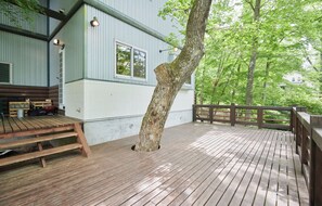 A wooden deck with a bench, a tree, and a building with a window and light fixtures. - morinoretreat  foresta di luce (Hatsukaichi)