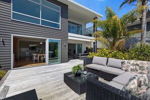 A modern two-story house with a balcony, outdoor seating area, and a dining space. - Magic on Molesworth in New Plymouth (New Plymouth)