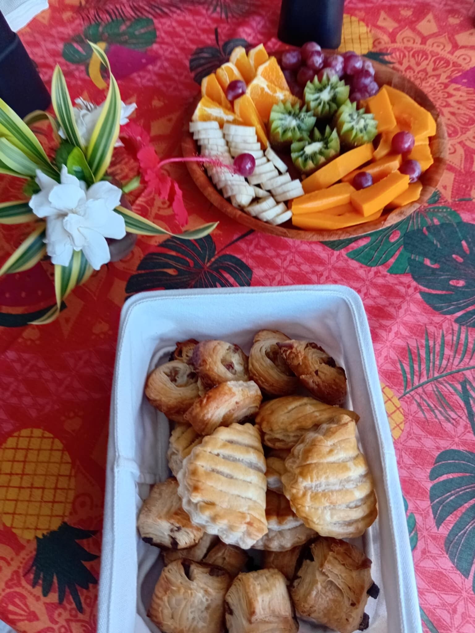 Een tafel met een fruitschaal en gebak.