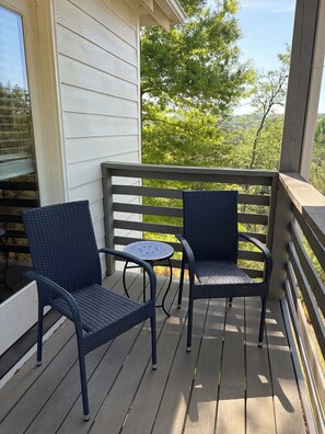 A wooden deck with two wicker chairs and a small round table. - Beautiful 4 bedroom in Vestavia Hills! Spacious Family Retreat! (Mountain Brook)