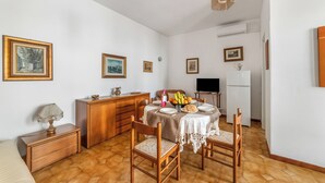 A dining area with a table set for two, wooden chairs, a white tablecloth, and a fruit bowl. - Leuca Relax&Sea n.3C, Castrignano del Capo, Italy (Castrignano del Capo)