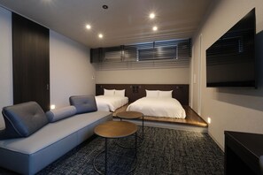 A modern hotel room with a sofa, two beds, a TV, and a carpeted floor. - Gran Marina (Osaka shi minato ku chikko)