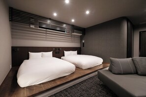 A modern hotel room with a wooden platform bed, a sofa, and a built-in air conditioning unit. - Gran Marina (Osaka shi minato ku chikko)