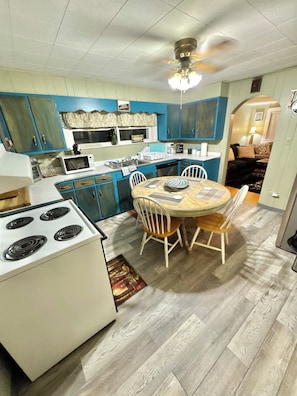 A compact kitchen with a dining area, a stove, and a ceiling fan. - ATV Trails and Skiing! Perfect 3-bedroom house in Rock (Rock)