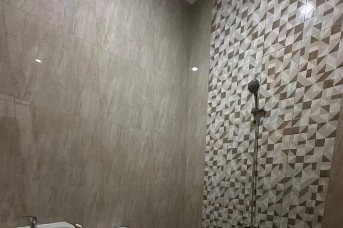 Un baño con lavamanos, inodoro y ducha.
