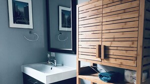 A bathroom with a white sink, a mirror, and wooden cabinets. - Spacious 3 bedroo, large livingroom and dining room. (Chicago)
