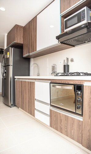 Eine moderne Küche mit Einbauofen, Mikrowelle und einem Edelstahlkühlschrank.