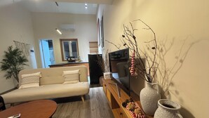 Un salon comprenant un canapé, une table basse, un téléviseur et des objets de décoration.