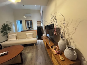 Ein Wohnzimmer mit einer Couch, einem Couchtisch, einem Fernseher und Dekoration.
