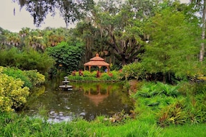 A tranquil garden with a gazebo, a pond, and lush greenery. - Bring Your Boat! Lift, Dock, Heated Pool & Sleeps 10 (Palm Coast)