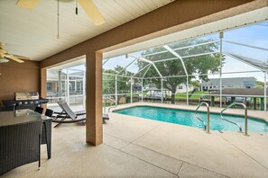 Ein Poolbereich im Innenbereich mit Grill und Liegestühlen.