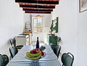 A dining room with a checkered tablecloth, a fruit bowl, and a view of the kitchen and outside. - Lovely apartment for 6 guests with hot tub, A/C, WIFI, TV, patio, pets allowed and panoramic view (Dorio)