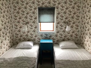 A room with two single beds, a small table, and a window with a view. - 4 Star Holiday Home in Hyltebruk (Hyltebruk)