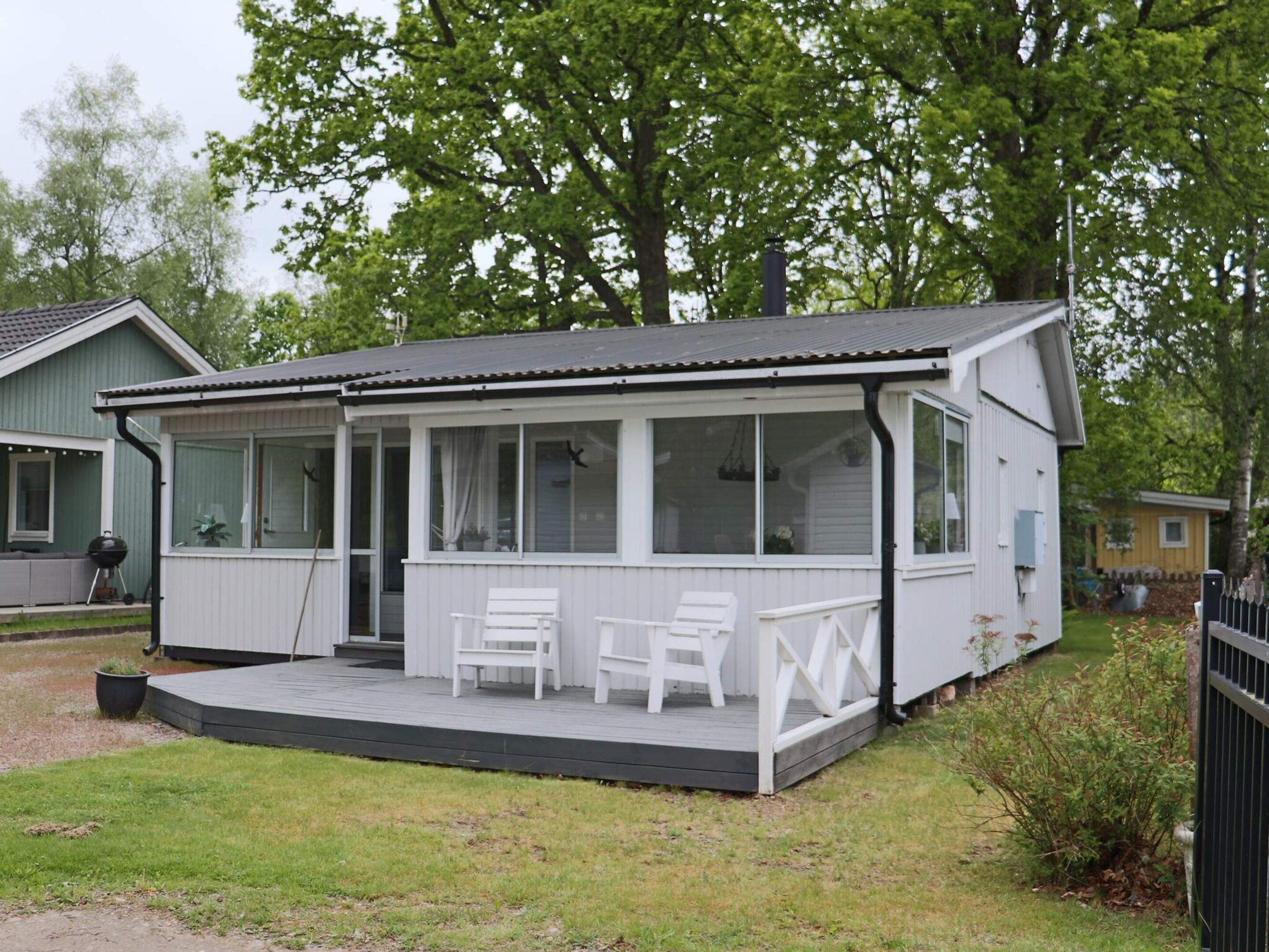 A single-story house with a covered porch, a small deck, and a grill area.