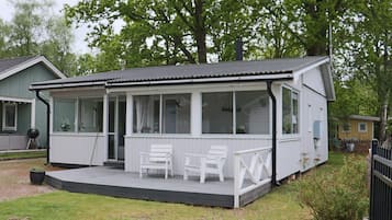 A single-story house with a covered porch, a small deck, and a grill area.