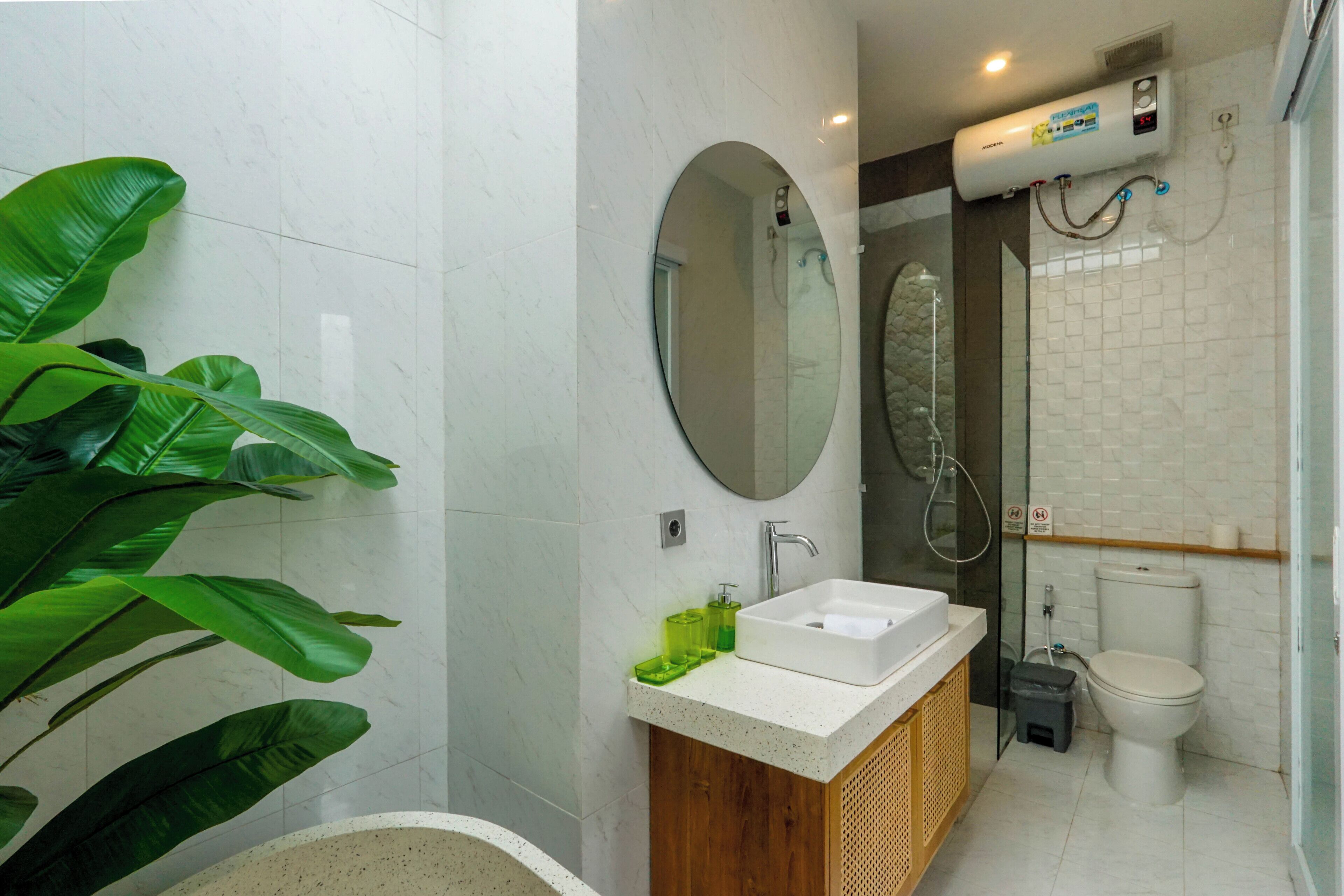 A bathroom with a bathtub, a sink, a toilet, a shower, and a large mirror.