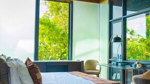 Quarto moderno com uma grande janela, uma cama, uma escrivaninha e uma cadeira.