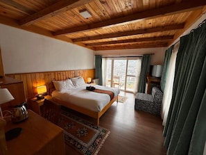 Una habitación con paneles de madera, una cama, un escritorio, una silla y un televisor.